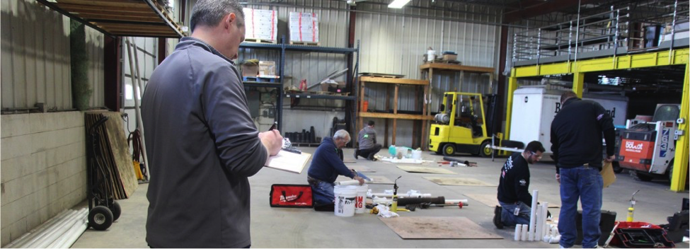 Wide shot of warehouse space and men working.